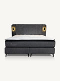 A modern platform bed with a dark gray upholstered headboard and footboard, featuring integrated warm LED light panels on either side of the headboard and a white mattress on top, shown against a plain off-white background.