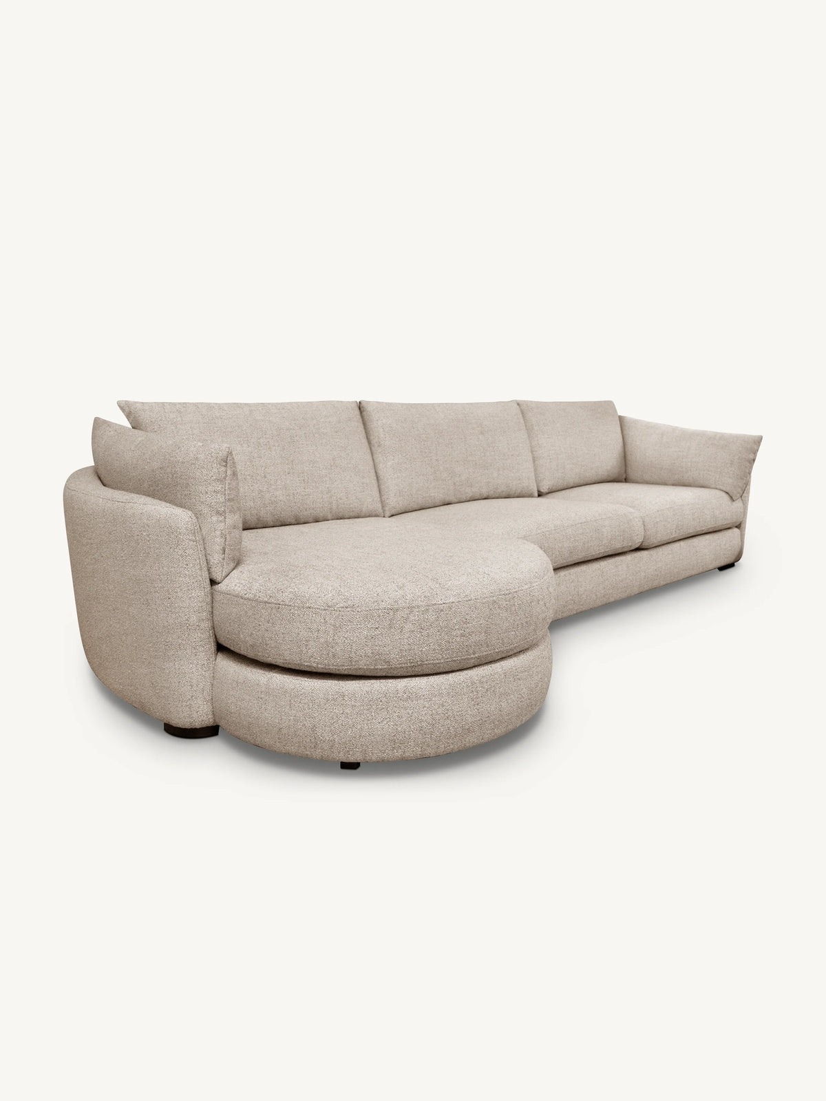 A modern curved upholstered sofa in a light beige textured fabric, featuring a chaise lounge on the left side, photographed against a solid off-white background.
