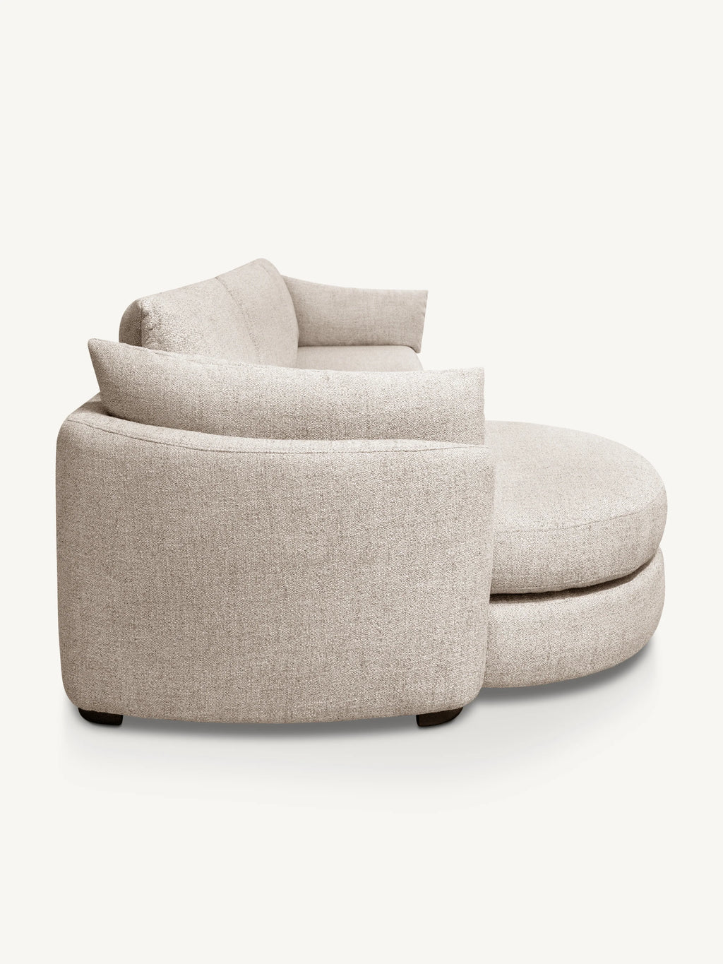 A modern curved upholstered lounge chair with a matching ottoman, shown from a three-quarter angle against a plain off-white background.