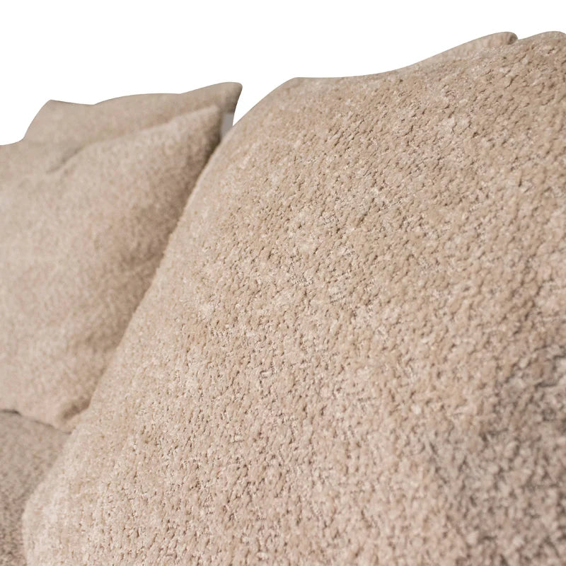 Close-up of a plush, textured beige throw pillow with a looped bouclé fabric, shown against a clean white background.