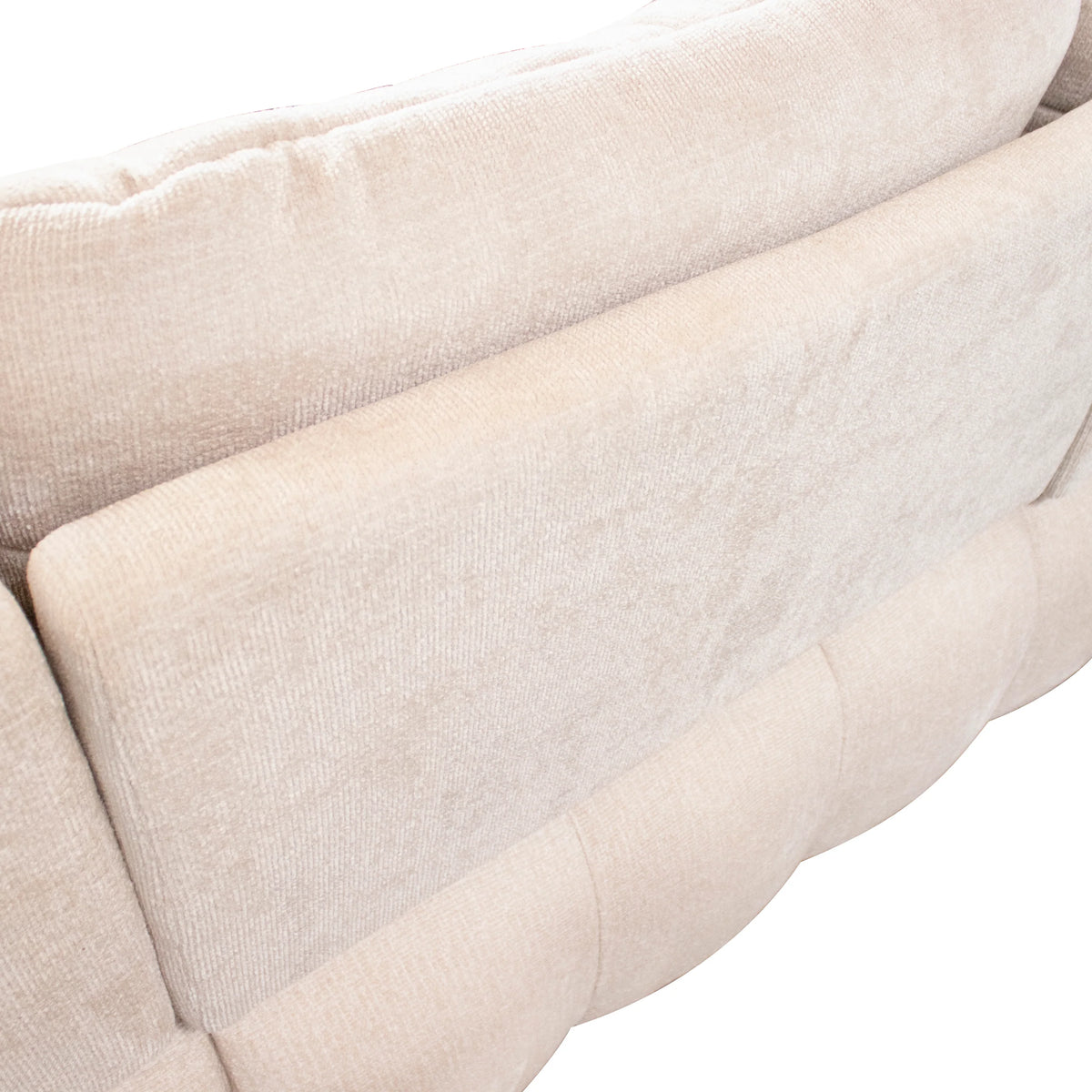 Close-up of a light beige upholstered sofa showing the fabric texture and tufted armrest detail against a white background.